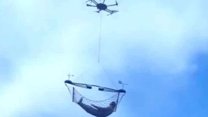 drone transporta a una persona en hamaca